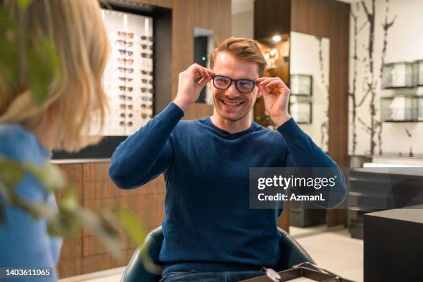 modisches paar kauft glücklich nach neuen brillen ein - augenoptiker stock-fotos und bilder
