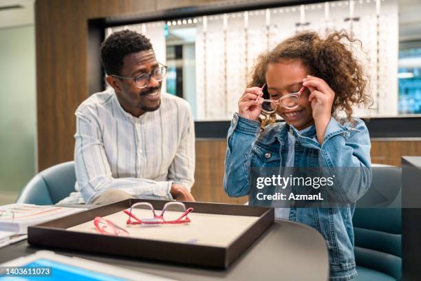 black father buying new glasses to beautiful daughter - oogmeetkunde stockfoto's en -beelden