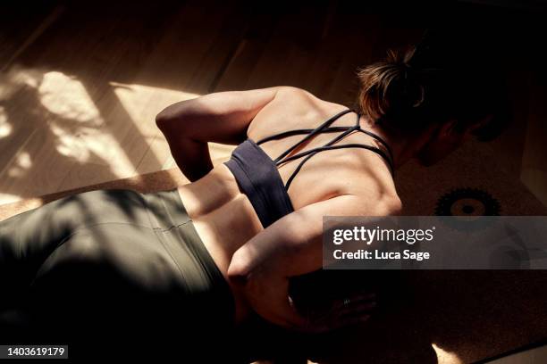 beautiful female practising yoga at home, on a golden sunny morning - lying on front stock pictures, royalty-free photos & images