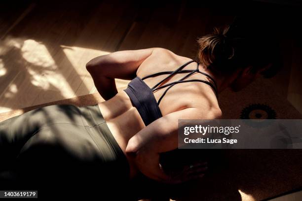 beautiful female practising yoga at home, on a golden sunny morning - pilates 個照片及圖片檔