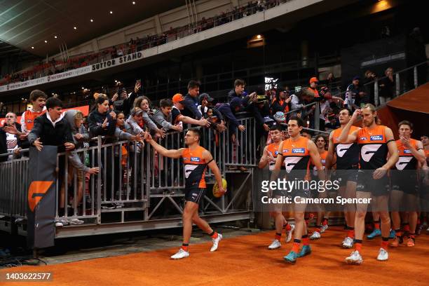 Stephen Coniglio of the Giants leads team mates onto the field during the round 14 AFL match between the Greater Western Sydney Giants and the...