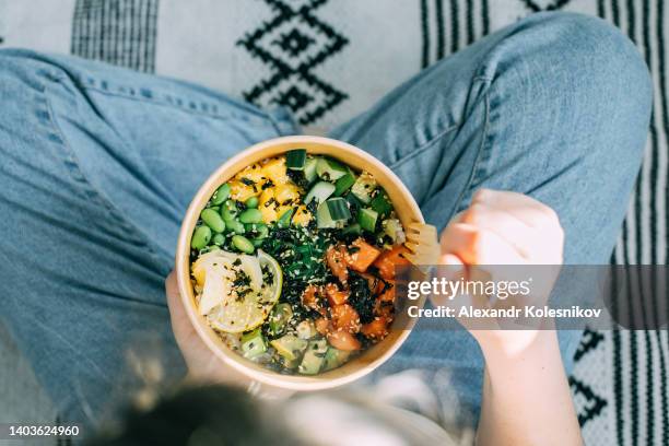 girl holding traditional hawaiian dish salmon poke bowl in hands. hawaiian and japanese cuisine. healthy food. - sushi nori foto e immagini stock