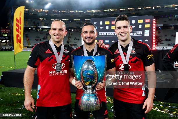 To R, Tom Christie, Bryn Hall and Will Jordan of the Crusaders pose with the Super Rugby Pacific trophy after winning the 2022 Super Rugby Pacific...