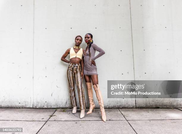 fashionable young women on urban sidewalk, full length - bottes grises photos et images de collection
