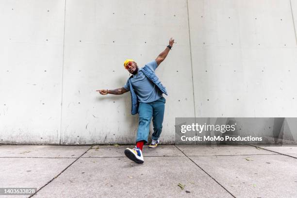 fashionable male professional dancer on urban sidewalk, full length - street style man stock pictures, royalty-free photos & images