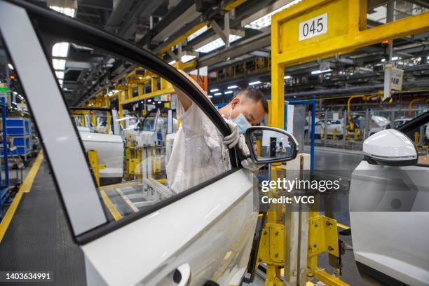 Employees work on the assembly line of Jetta VS7 SUV at the Chengdu branch of FAW-Volkswagen Automobile Co., Ltd, a joint venture between FAW Group...