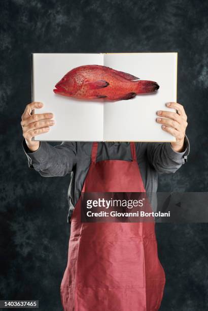 man with fish menu on his face - mero fotografías e imágenes de stock