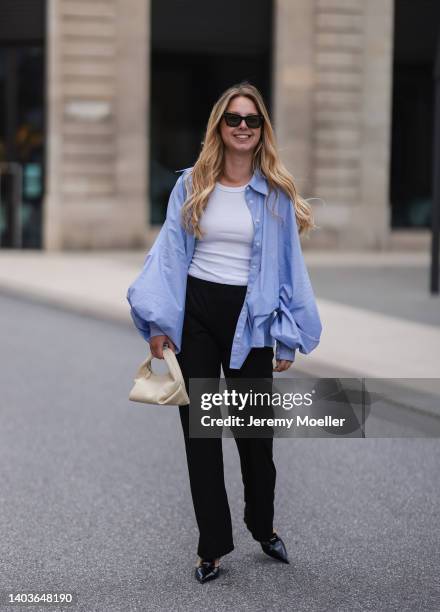 Liesa Späht seen wearing a black sunglasses from Celine, a white basic tank top from H&M, a blue shirt blouse from SoSue, a black wide leg pants...