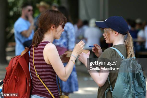 Mother and her daughter try each other's ice cream during hot summer weather temperatures on June 18, 2022 in Berlin, Germany. The German weather...