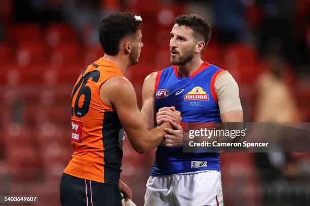 Jake Riccardi of the Giants and Marcus Bontempelli of the Bulldogs embrace following the round 14 AFL match between the Greater Western Sydney Giants...