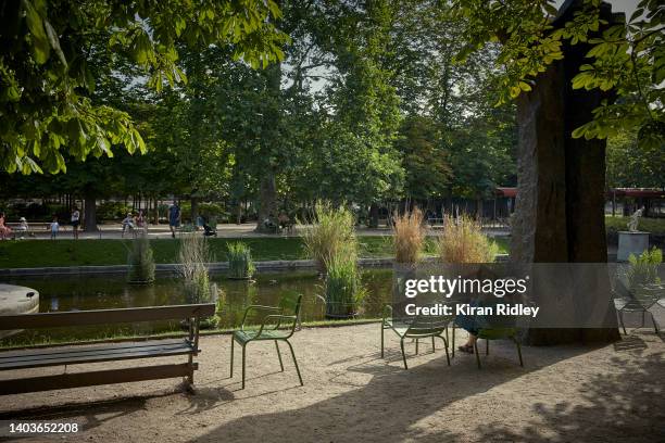 Parisian sits in the early morning sunshine in the Tuileries Gardens in Paris, as temperatures in the City are expected to set a new record for the...