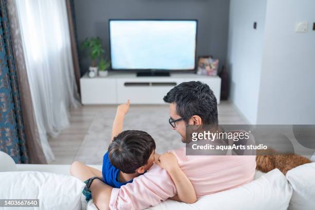 watching tv together - changing channels stockfoto's en -beelden