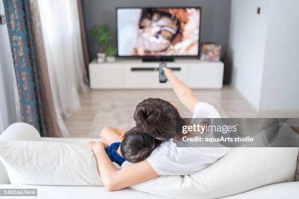 watching tv together - family watching tv from behind stockfoto's en -beelden
