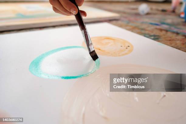 primer plano de la pintura a mano sobre lienzo en el taller - manos pintadas fotografías e imágenes de stock