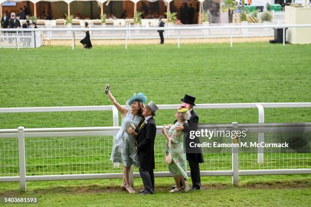 Racegoers take a selfie on the side of the course during Royal Ascot 2022 at Ascot Racecourse on June 18, 2022 in Ascot, England.
