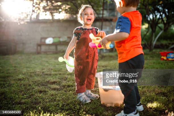 children having fun water fight - sibling fight stock pictures, royalty-free photos & images