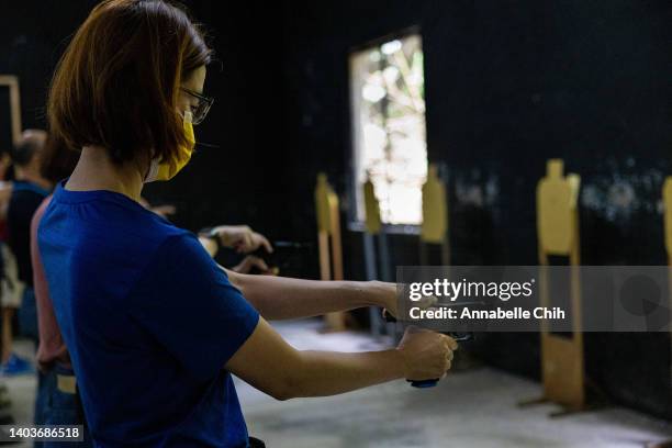 Female trainee practices using an airsoft gun during an airsoft gun training session for beginners held by Polar Light on June 18, 2022 in New Taipei...