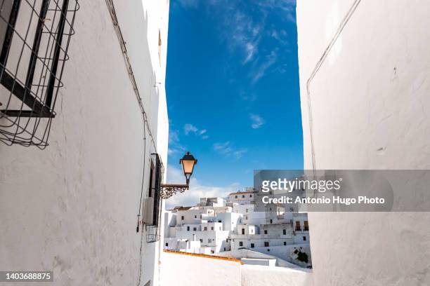 street and set of white houses against blue sky in vejer de la frontera, cadiz, spain. - andalusia stock-fotos und bilder