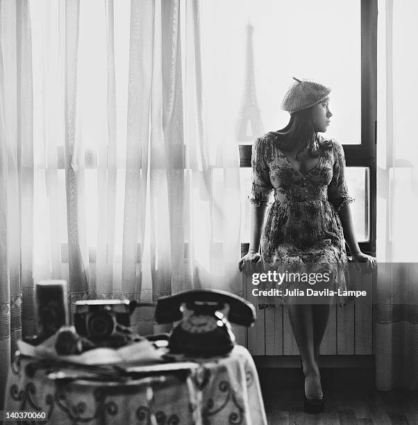 young woman by window - relampago stockfoto's en -beelden