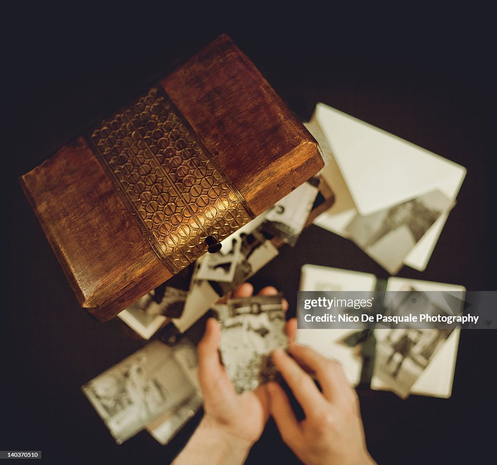 Hands of man holding old photographs