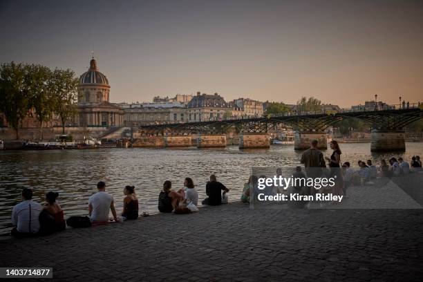 Parisians sit by the River Seine after a day of soaring temperatures of close to 40°C in what is expected to be a new record for the hottest June day...