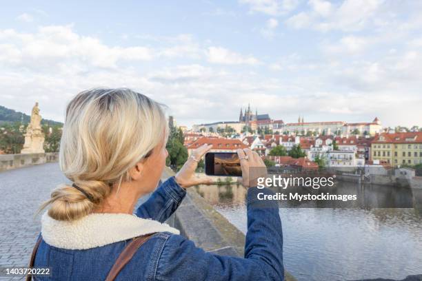 young woman in prague using a mobile phone - czech republic skyline stock pictures, royalty-free photos & images