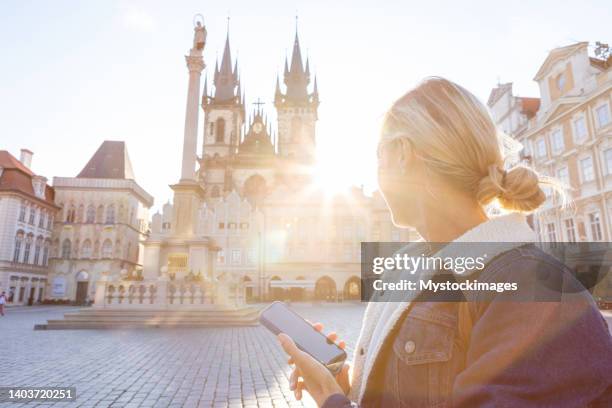 young woman in prague using a mobile phone - czech republic skyline stock pictures, royalty-free photos & images