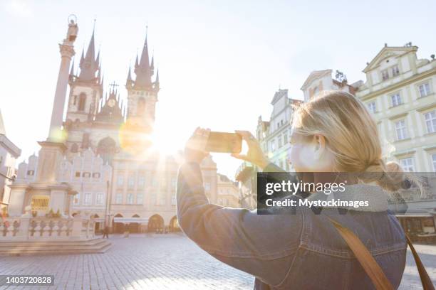 young woman in prague using a mobile phone - czech republic skyline stock pictures, royalty-free photos & images