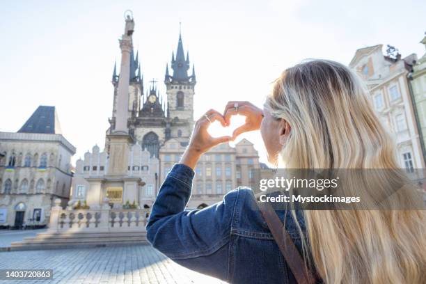 young woman loves prague, she makes heart with hands - czech republic city stock pictures, royalty-free photos & images