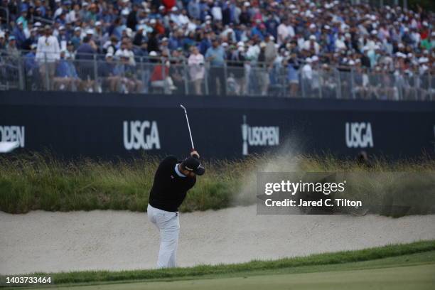 Jon Rahm of Spain plays a shot from a fairway bunker on the 18th hole during the third round of the 122nd U.S. Open Championship at The Country Club...