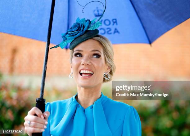 Charlotte Hawkins shelters under an umbrella as she attends day 5 of Royal Ascot at Ascot Racecourse on June 18, 2022 in Ascot, England.