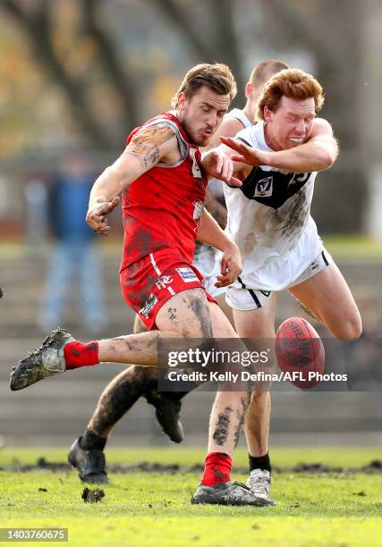 Liam Mackie of the Bullants kicks the ball under pressure from Jesse Joyce of the Sharks during the round 13 VFL match between the Northern Bullants...