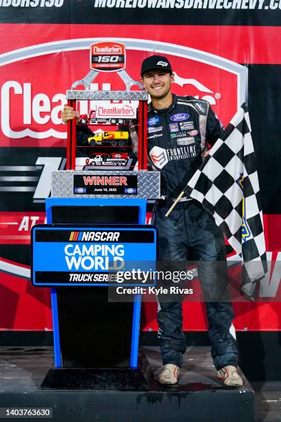 Todd Gilliland, driver of the Frontline Enterprises Ford, poses by the trophy after winning the NASCAR Camping World Truck Series Clean Harbors 150...