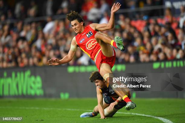 Wil Powell of the Suns is tackled while kicking the ball during the round 14 AFL match between the Gold Coast Suns and the Adelaide Crows at Metricon...