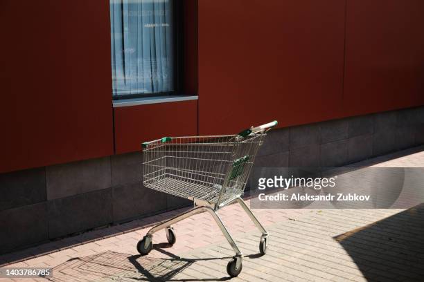 a shopping cart or cart for shopping products and goods, near a shopping center, hypermarket or supermarket. the concept of the trade industry, the sphere of consumption. - discount store stock pictures, royalty-free photos & images