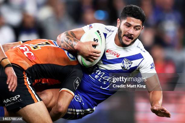 Zach Dockar-Clay of the Bulldogs is tackled during the round 15 NRL match between the Canterbury Bulldogs and the Wests Tigers at CommBank Stadium,...