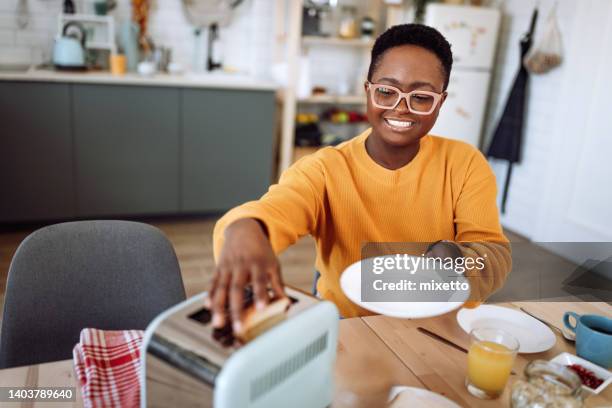 joven feliz durante su ritual matutino - toaster fotografías e imágenes de stock