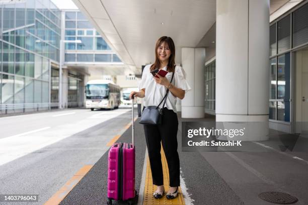 full length portrait of female tourist standing on airport bus terminal - portraits of people passport imagens e fotografias de stock