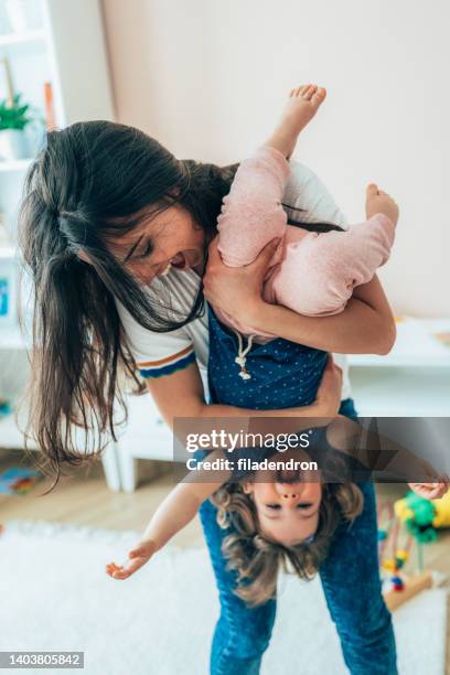 mutter und kleinkind spaß - eltern baby hochheben stock-fotos und bilder
