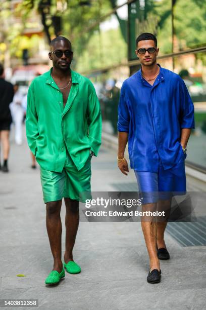 Guest wears black sunglasses, gold necklace, a neon green silk oversized shirt, matching neon green silk shorts, a silver watch, neon green shiny...