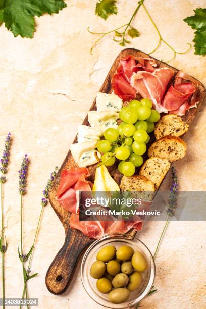 antipasto board with prosciutto, salami, bruschettas, cheese, olives - wooden tray stock pictures, royalty-free photos & images