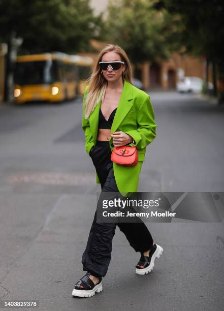 Sonia Lyson seen wearing a white Bottega Veneta sunglasses, a black bra top from Trendyol, a yellow green/acid green oversize blazer from Zara, a...