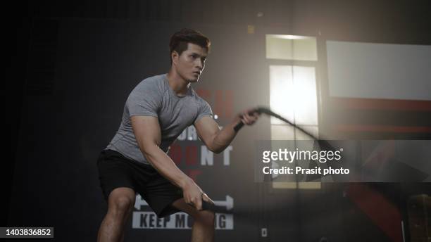 asian man with battle rope battle ropes exercise in the fitness gym, exercises concept. - asian man exercise stock pictures, royalty-free photos & images