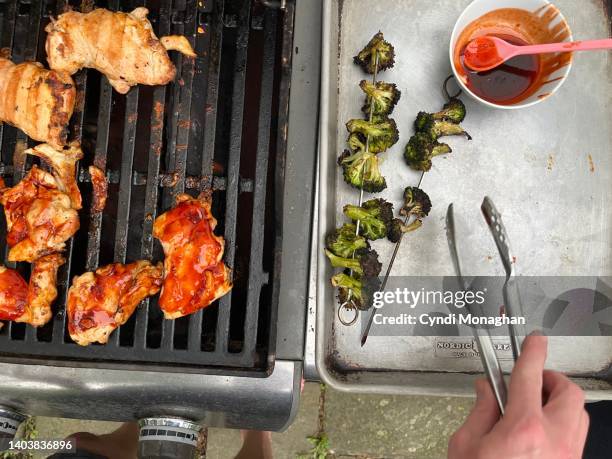 close up of a man cooking food on a grill - bbq chicken stock-fotos und bilder