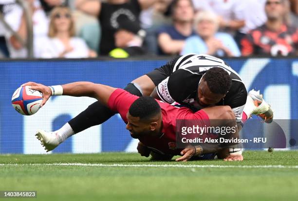 Joe Cokanasiga of England crosses for Englands first try whilst being tackled by Virimi Vakatawa of Barbarians during the International match between...