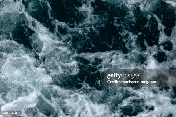 drone shot showing waves crashing towards the shore - europäisches nordmeer stock-fotos und bilder
