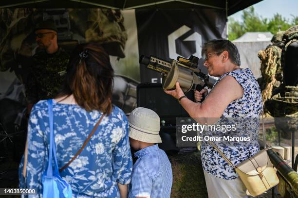 An elderly woman holds a grenade launcher during a military picnic organized by the Foundation GROT and branches of the Polish army on June 19, 2022...