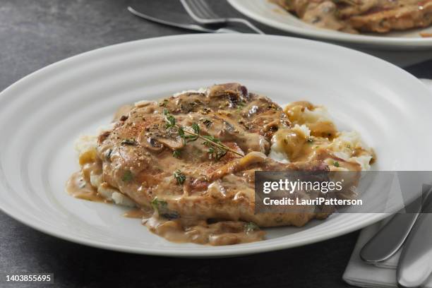 geschmorte schweinekoteletts in cremiger pilzsauce - schweinekotelett stock-fotos und bilder