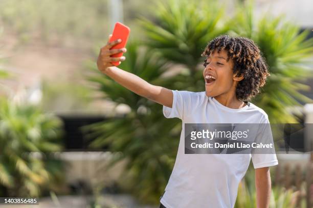 10 year old african american boy taking selfie in the yard - boy 10 11 stock pictures, royalty-free photos & images