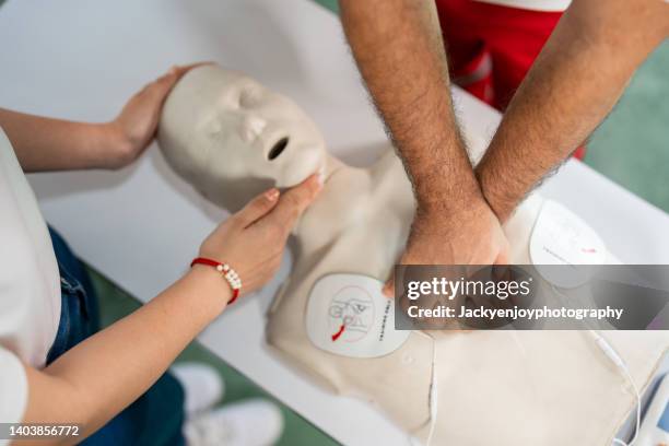 cropped hands of doctor performing cpr on dummy - würgen stock-fotos und bilder